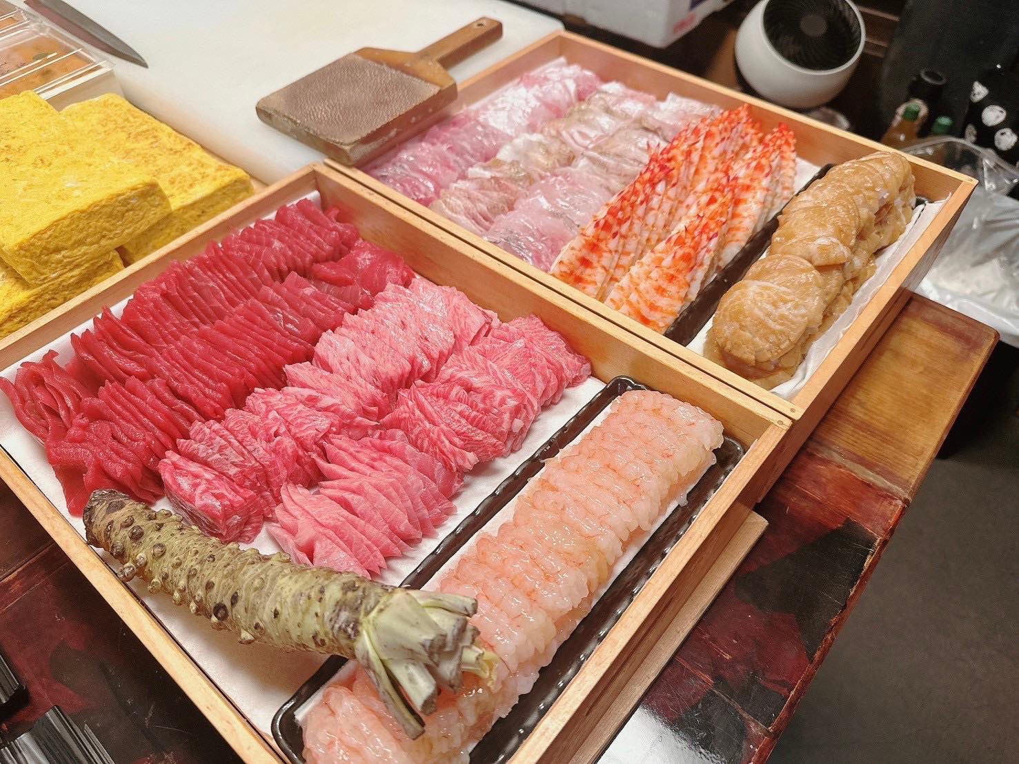 鮪・海老・玉子などのネタを並べた寿司バイキングの準備